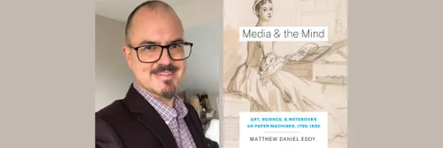 A man wearing glasses and smiling at the camera next to a book cover of a painting of woman in period dress. The book is called Media & Mind.