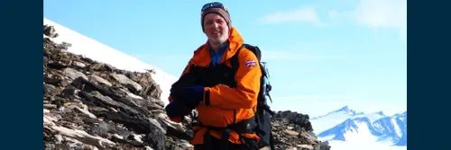Professor Mike Bentley stands in front of a rocky and snowy landscape