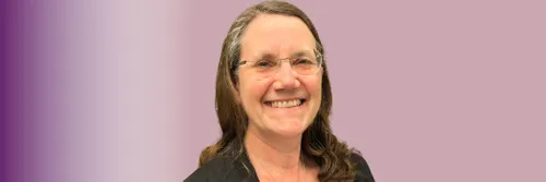 An image of Charlotte Clarke smiling, on a purple background