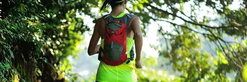Female ultrarunner with a backpack in the forest