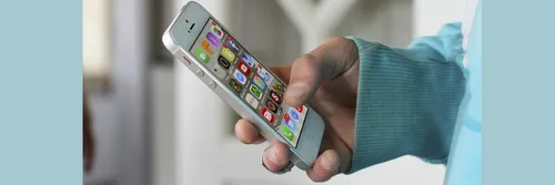 A close up of a person holding a phone with apps displayed on the screen