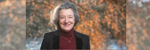 VC Karen O'Brien smiling outdoors with an autumnal tree behind her