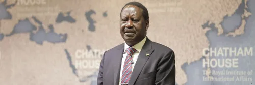 Raila Odinga speaking at an event. He is wearing a suit and tie and standing in front of a backdrop which reads Chatham House.