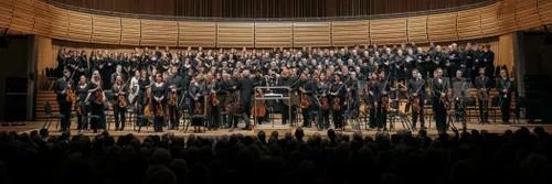 An orchestra and chorus standing on stage