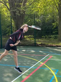 A male student playing tennis