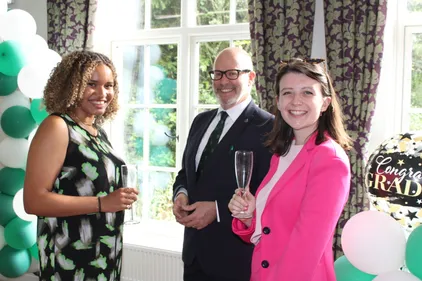 Vice-Principal and two students celebrating at drinks reception after graduation