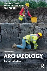 Book cover of the sixth edition of 'Archaeology An Introduction', authored by Hannah Cobb, Kevin Green and Tom Moore. The cover photo shows two archaeologists in high vis vests and hard hats working on an excavation site, with equipment such as trowels, shovels and buckets. The Routledge logo is visible in the bottom left corner.