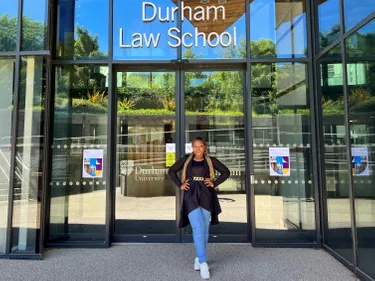 Ifeoma standing in front of the entrance to the Durham Law School