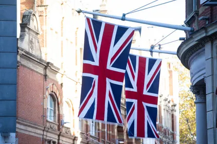Two UK flags hanging from a building