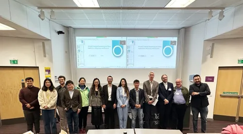 A Group of people smiling for the camera in front of a presentation