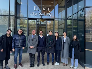 A group of people standing outside Durham Law School