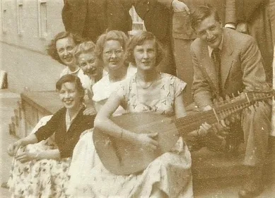 A woman with a lute in front of a group of students