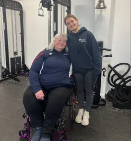 Jodie Newman posing with Paralympian in a gym