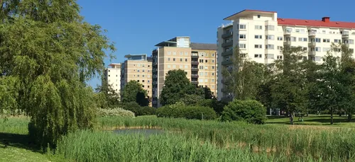 A row of buildings in a green landscape.
