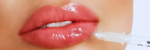 A closeup of a woman's lips with a needle injecting fluid