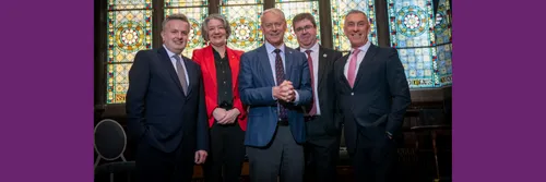 Representatives of the five North East universities stood in front of a stained glass wiindow