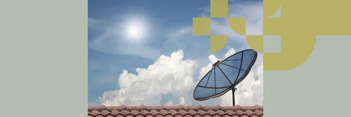 A round satellite dish attached to a tiled roof