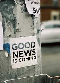 Poster on street lamp stating good news