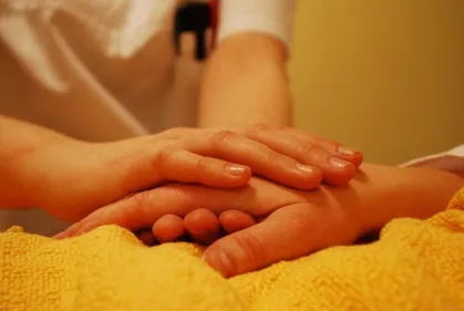 Nurse holding a patients hand