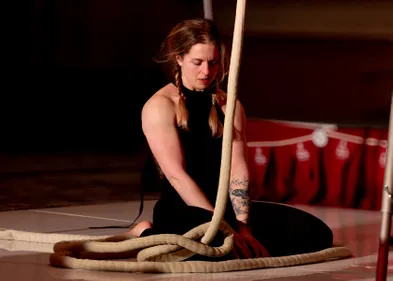 Amy Pearson sat on the floor at the beginning of an aerial performance with ropes.