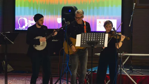 A group of three musicians playing on stage.