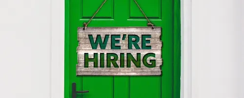Green wooden door with a sign that reads 'We're hiring'.