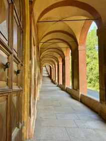 A long corridor with arched ceiling and orange pillars