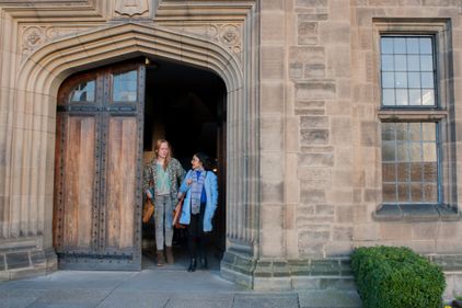Two students exiting a historic building.