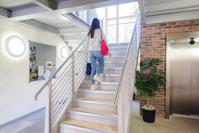 A student walking up the stairs in the Garth