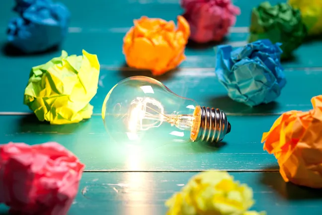 Incandescent bulb and colourful notes