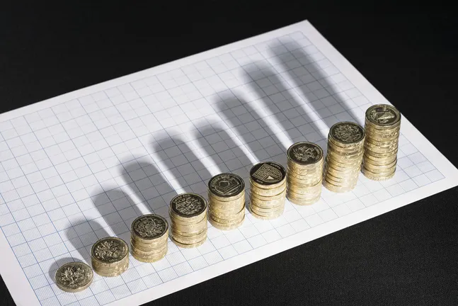 Stacks of coins create shadows across a graph