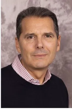 Man wearing dark jumper with red and white checked collar