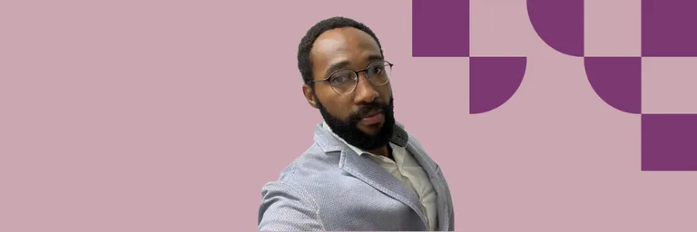 A man wearing glasses smiling at the camera