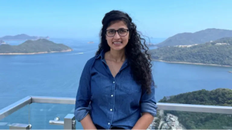 Image of Assistant Professor Renu Singh with the ocean and mountains in the background.