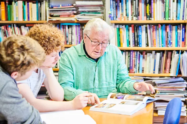 Tutor reading through book with students