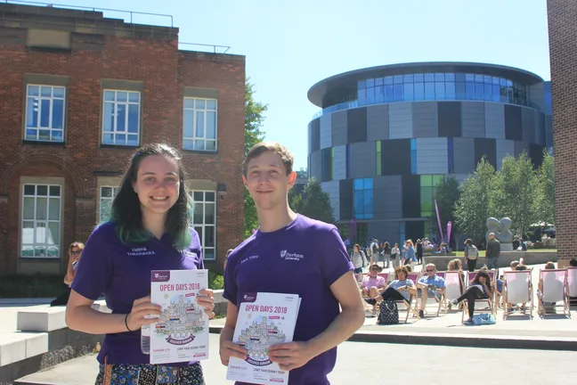 Two Durham students on campus with open day brochures