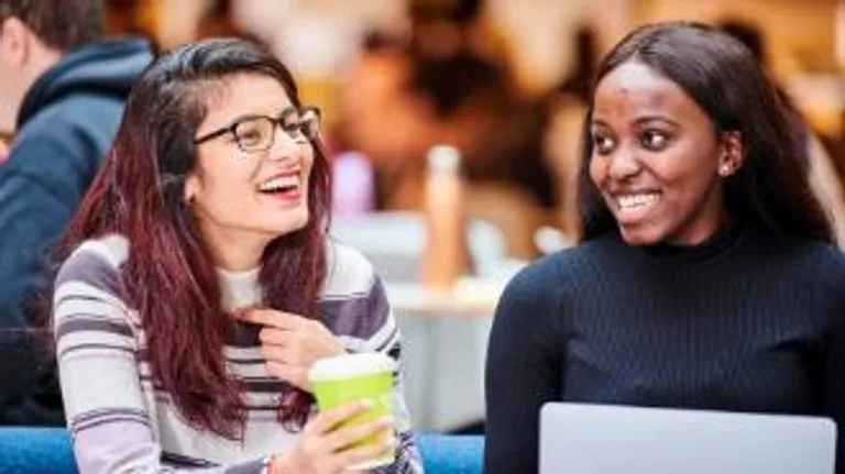 Two students studying in Teaching and Learning Centre with hot drink