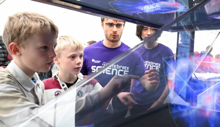 Young children and students looking at a science experiment
