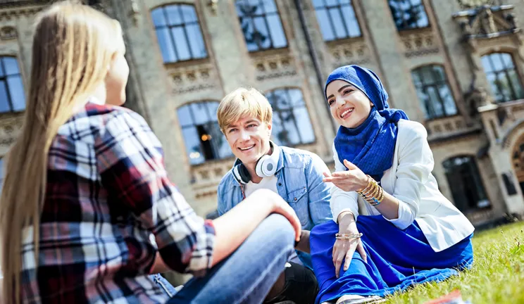 Students relaxing in the sun on Palace Green