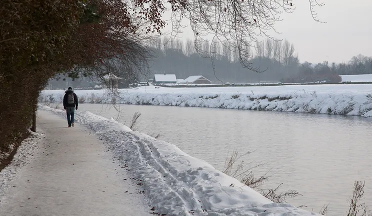 The River Wear in Winter with snow on the bank side and a lone person walking