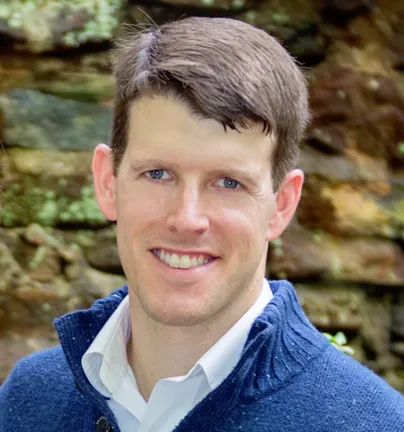 A smiling man with short dark hair