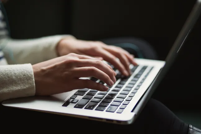 Someone typing on a laptop