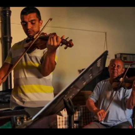 HOPA IIDE film screenshot showing a boy playing a violin