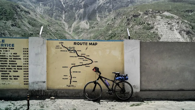 A bicycle leaning against a wall with a map painted on it.