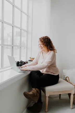 woman sitting by a window working from home