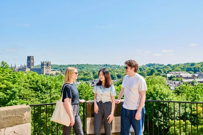 Student chatting with 鶹ý and the Cathedral in the background