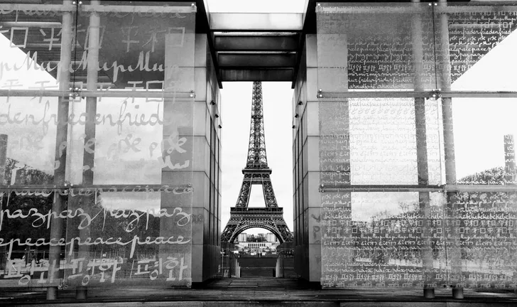 The Eiffel Tower framed by glass panels inscribed with writing in different languages