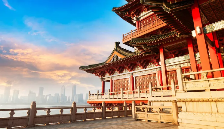 Ancient Chinese architecture with a city skyline in the background