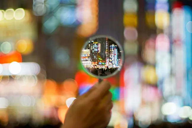 A city street seen through a magnifying glass, with the background blurred out
