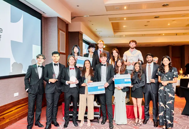 Students at an awards ceremony holding up their certificates and trophies